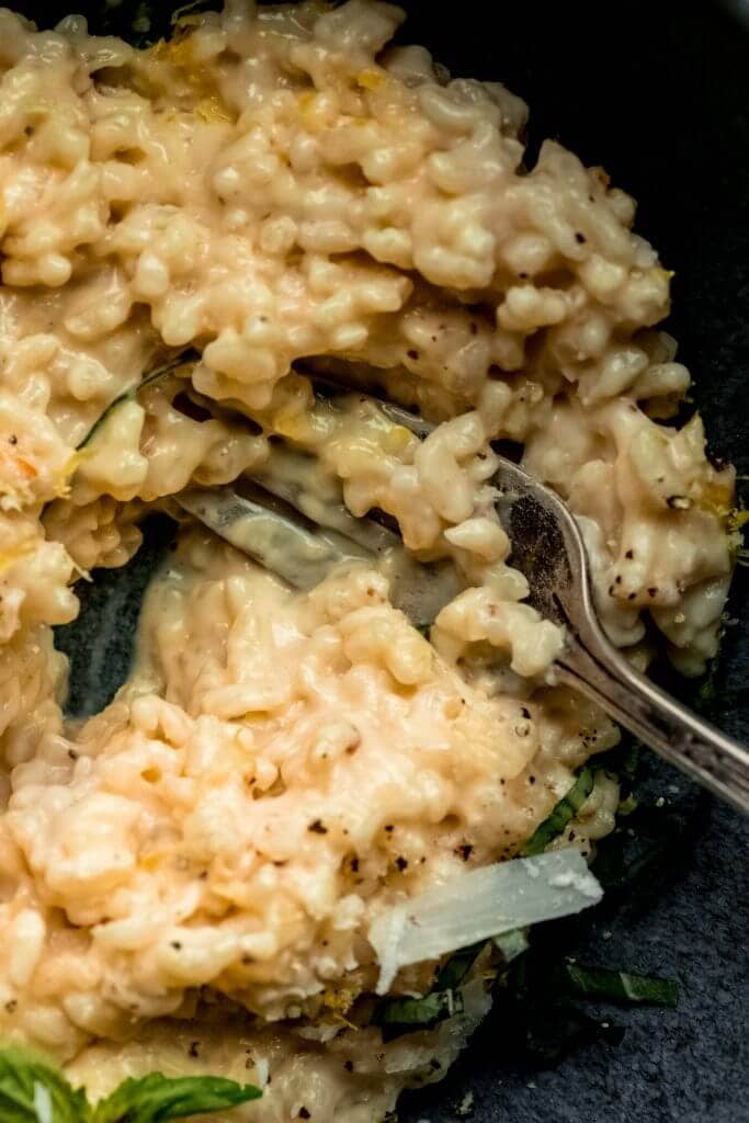 Close up of creamy lemon risotto with fork. 
