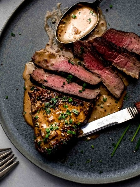 Sliced steak diane on plate.