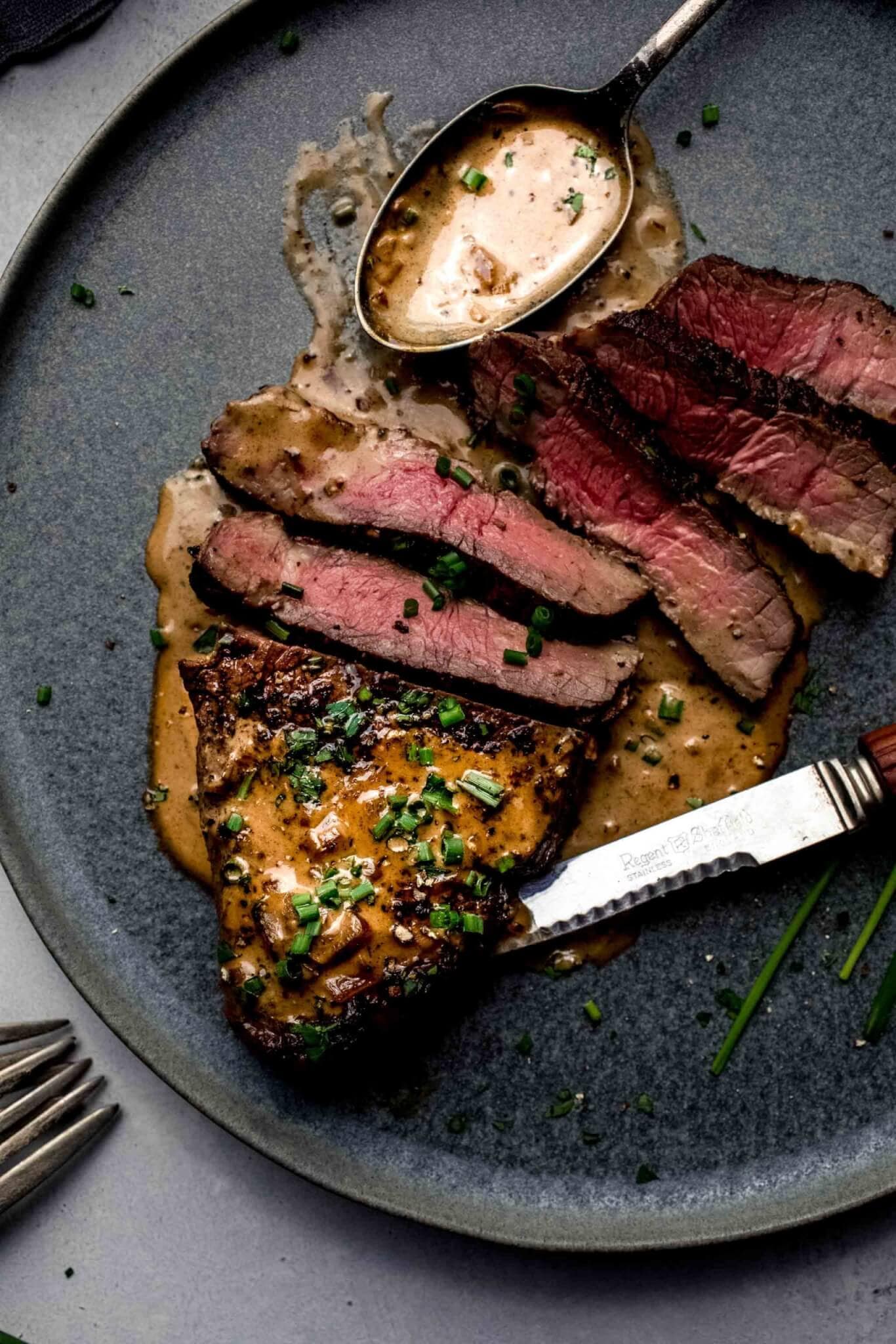 Sliced steak diane on plate.