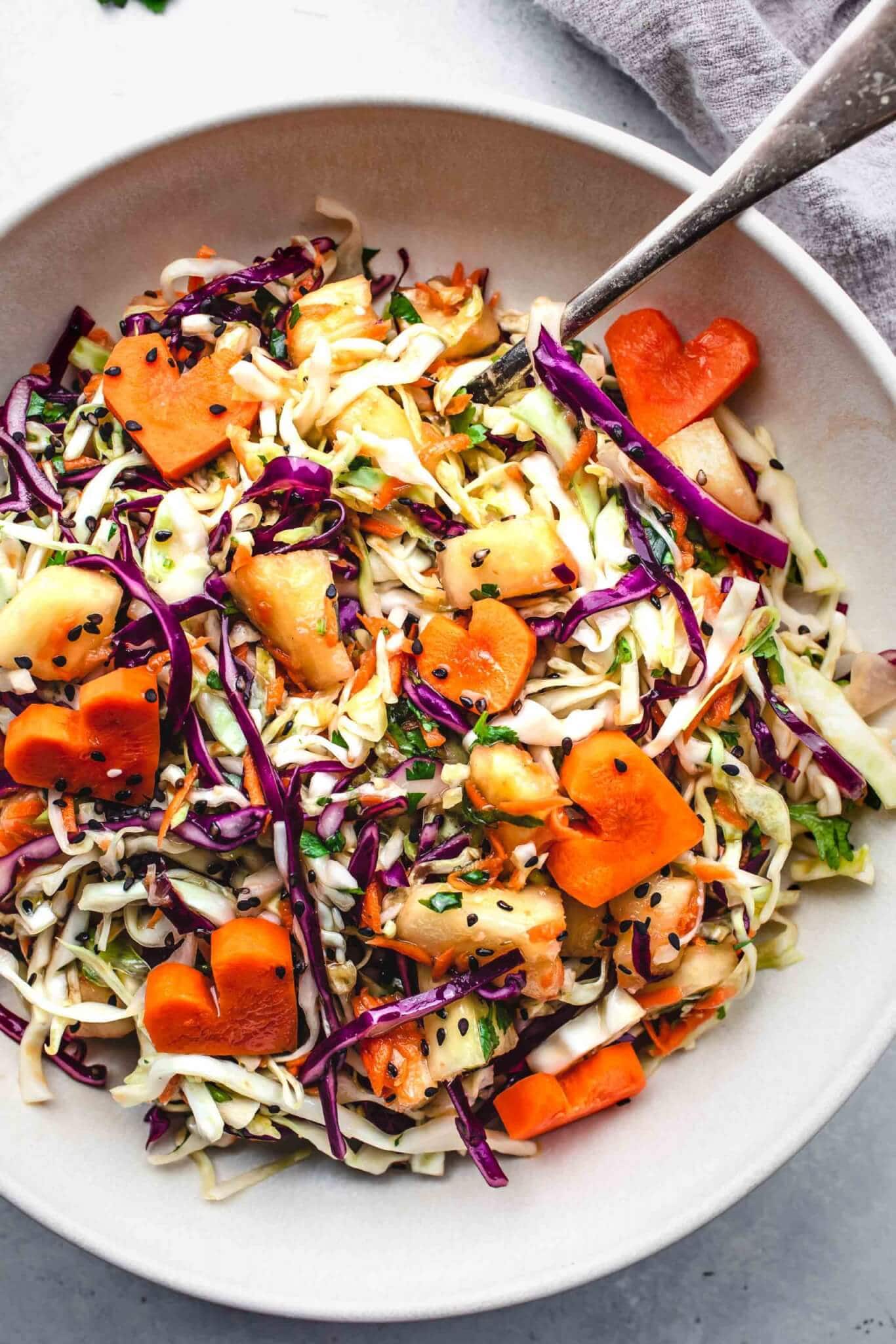 Prepared hawaiian slaw in bowl with heart shaped carrots.