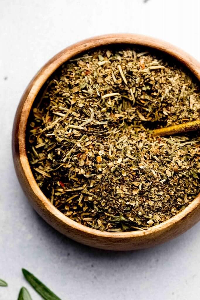 Overhead close up of bowl of italian seasoning with small spoon.