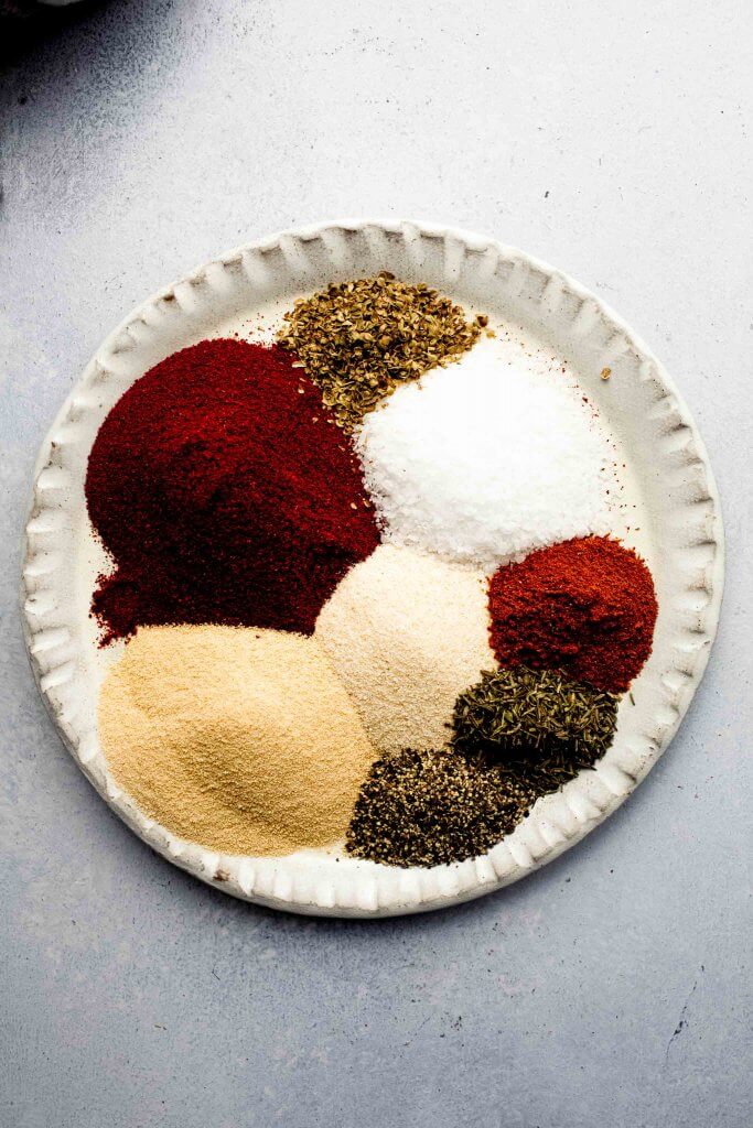 Scoops of ingredients for cajun seasoning on plate. 