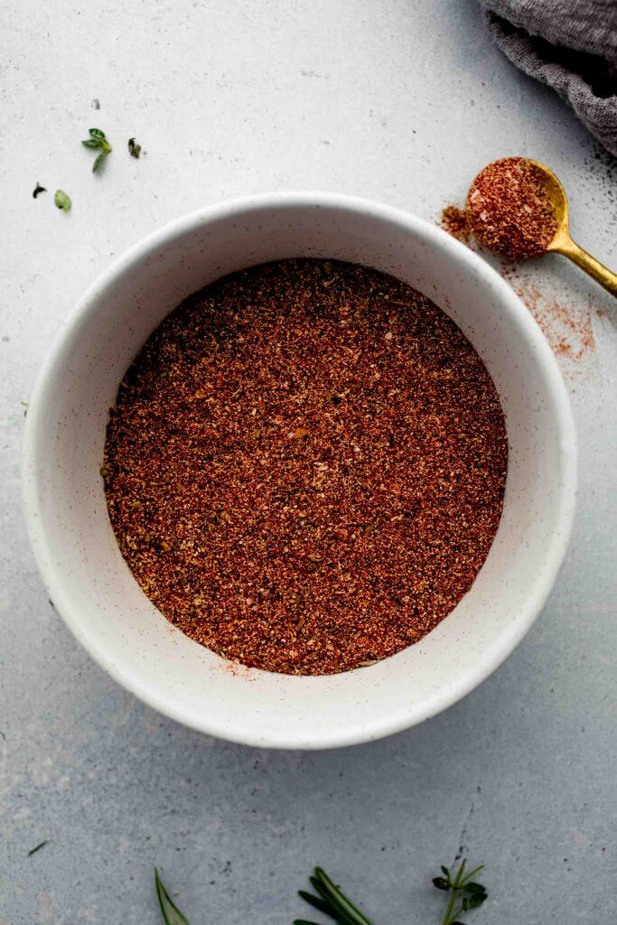 Cajun seasoning in small bowl on counter. 