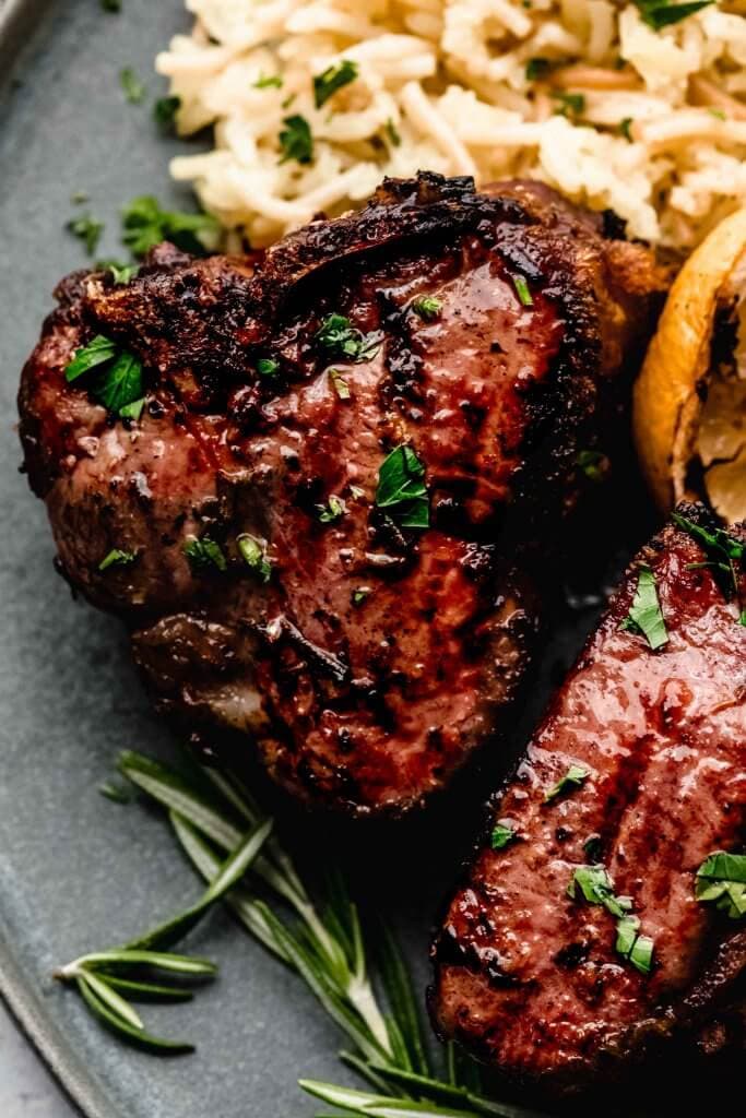 Close up of grilled lamb chops on plate. 