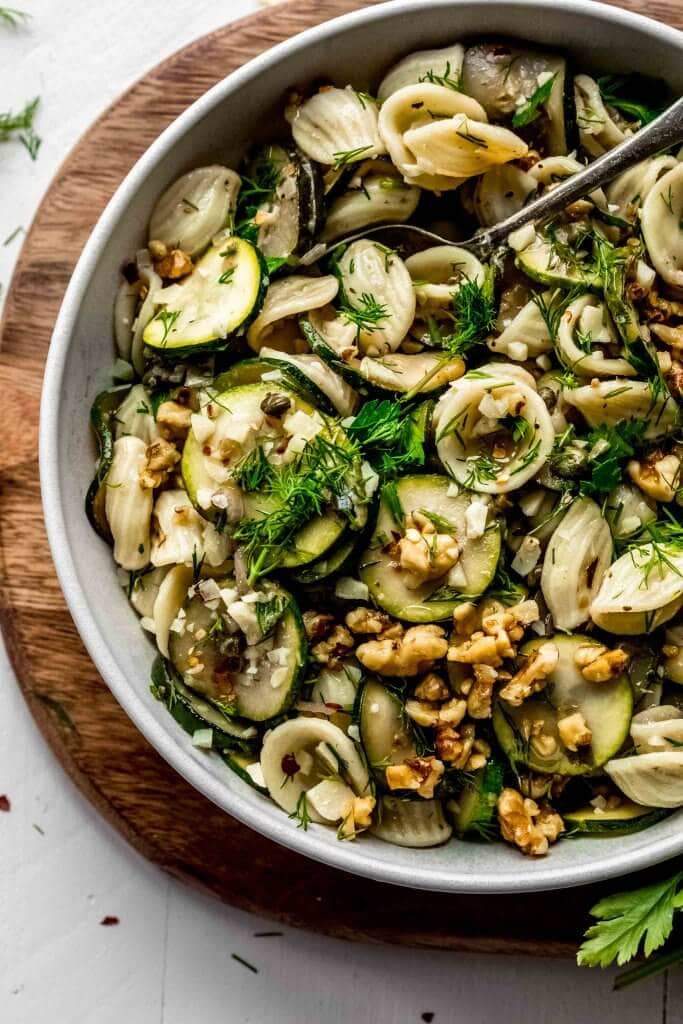 Overhead close up of summer pasta salad in white bowl. 