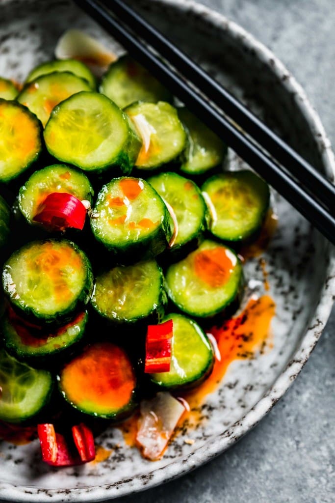 Close up of din tai fung cucumber salad on grey plate with chopsticks. 