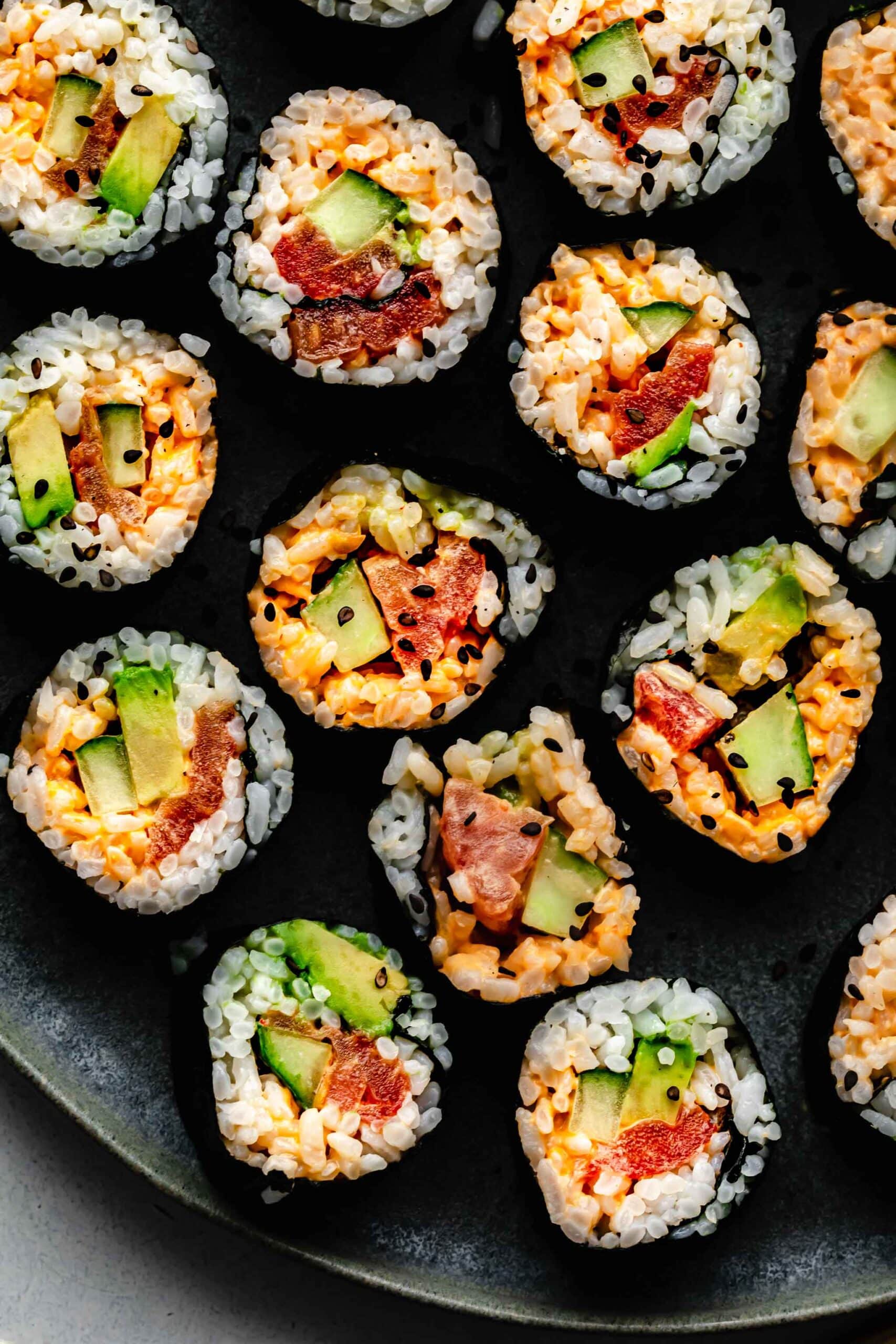 CLOSEUP OF VEGETARIAN SUSHI ROLLS ON GREY PLATE.