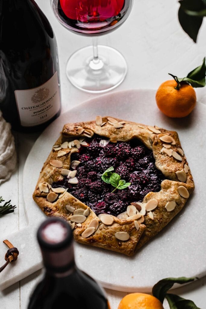 Galette next to bottle of red wine.