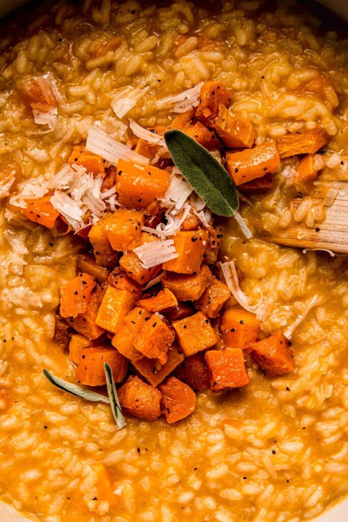 Close up of risotto in pot topped with cubed squash.