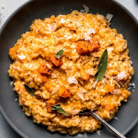 Butternut squash risotto in grey bowl with spoon.