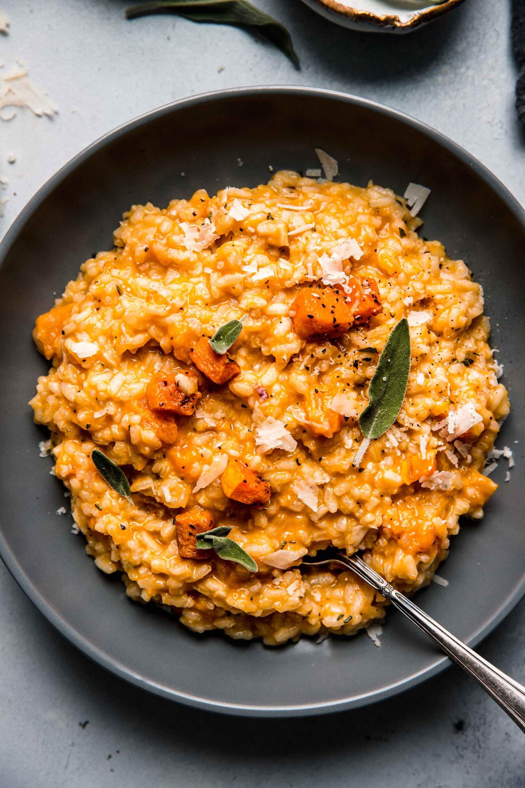 Butternut squash risotto in grey bowl with spoon.