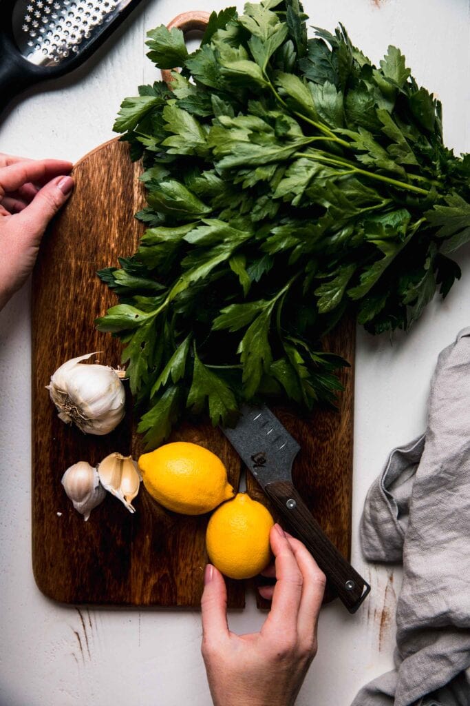 Cutting board with lemons, garlic and parsley. 