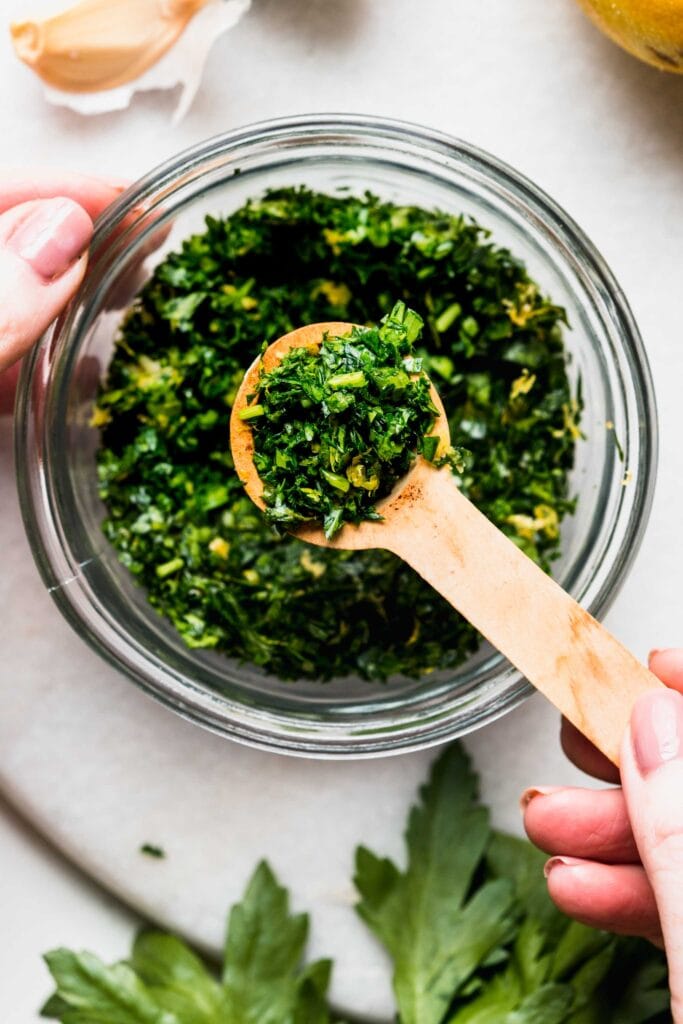 Overhead close up of bowl of gremolata with spoon. 