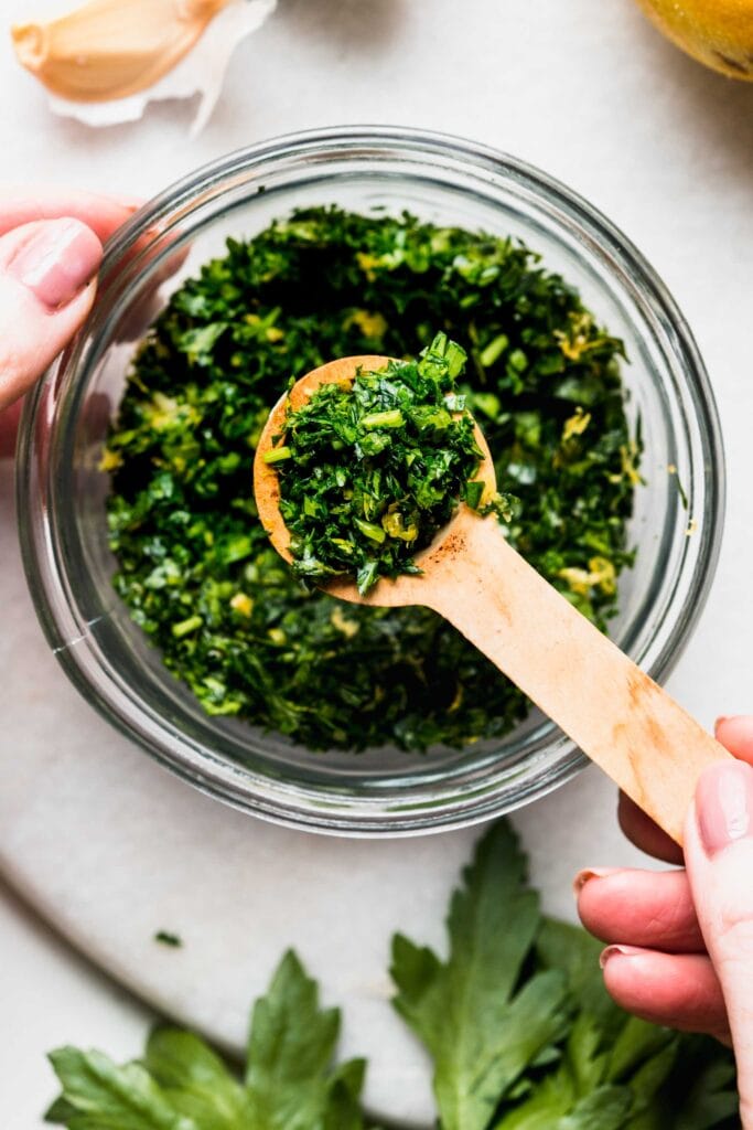 Overhead close up of bowl of gremolata with spoon.