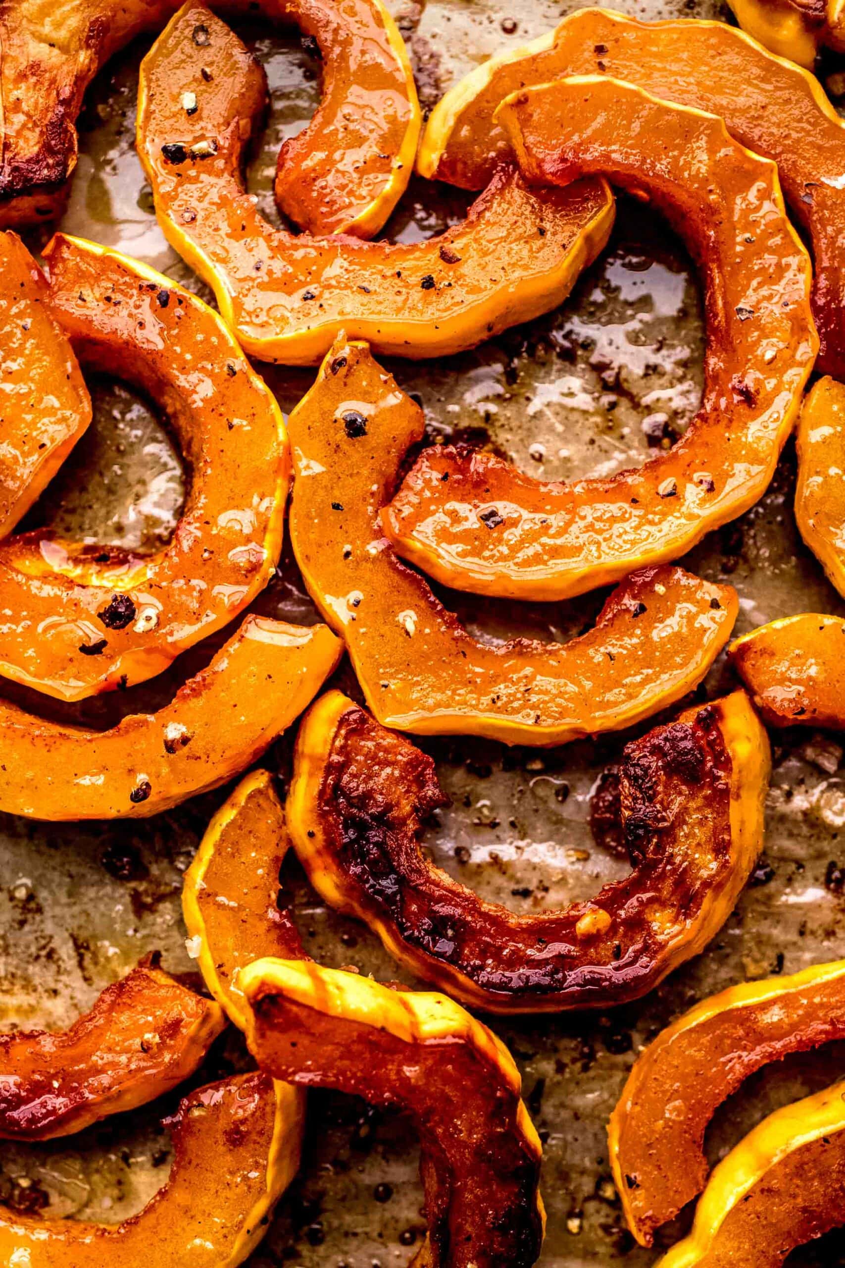 Close up of roasted delicata squash on baking sheet.