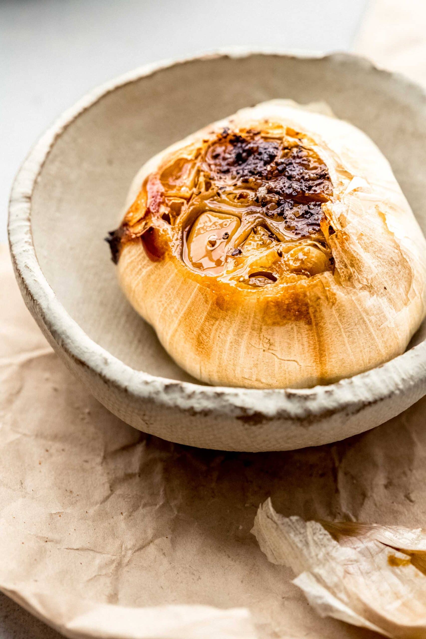 ROASTED GARLIC IN SMALL SERVING DISH.