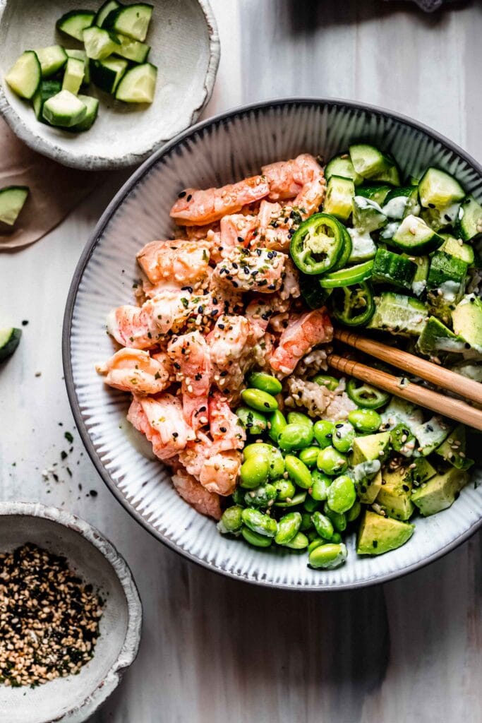 Shrimp sushi bowl topped with edamame, cucumbers and avocado.
