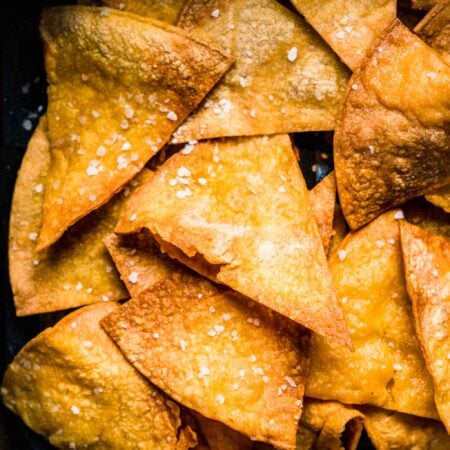 Extreme close up of tortilla chips in air fryer basket.