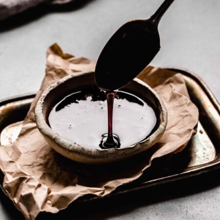 Spoon drizzling kecap manis into bowl.