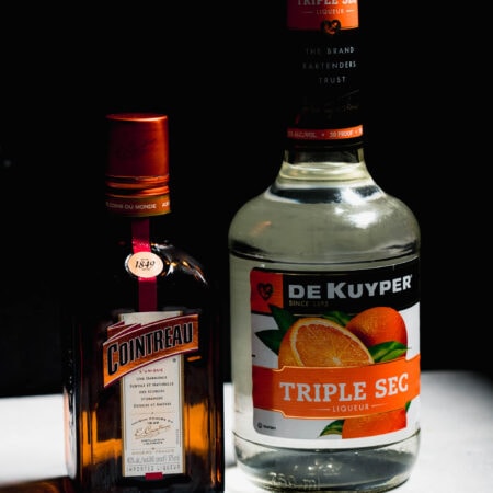Bottle of cointreau next to bottle of triple sec.
