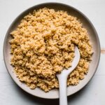 Overhead shot of instant pot quinoa in white bowl with spoon.