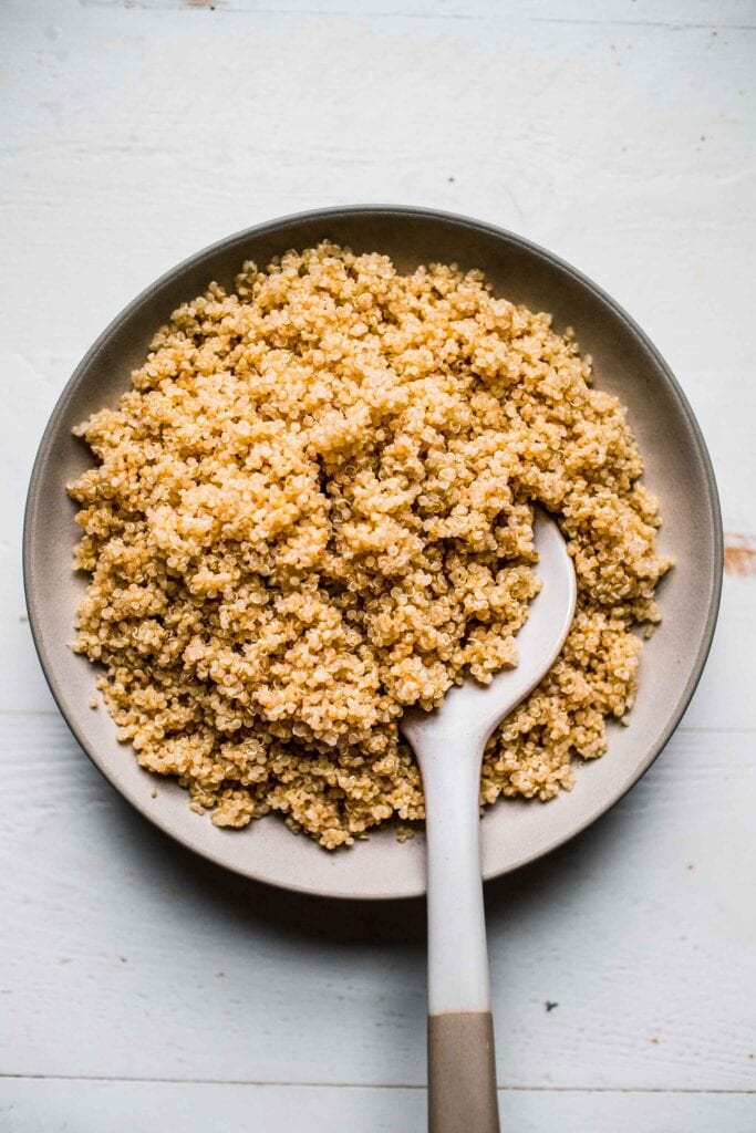 Overhead shot of instant pot quinoa in white bowl with spoon.