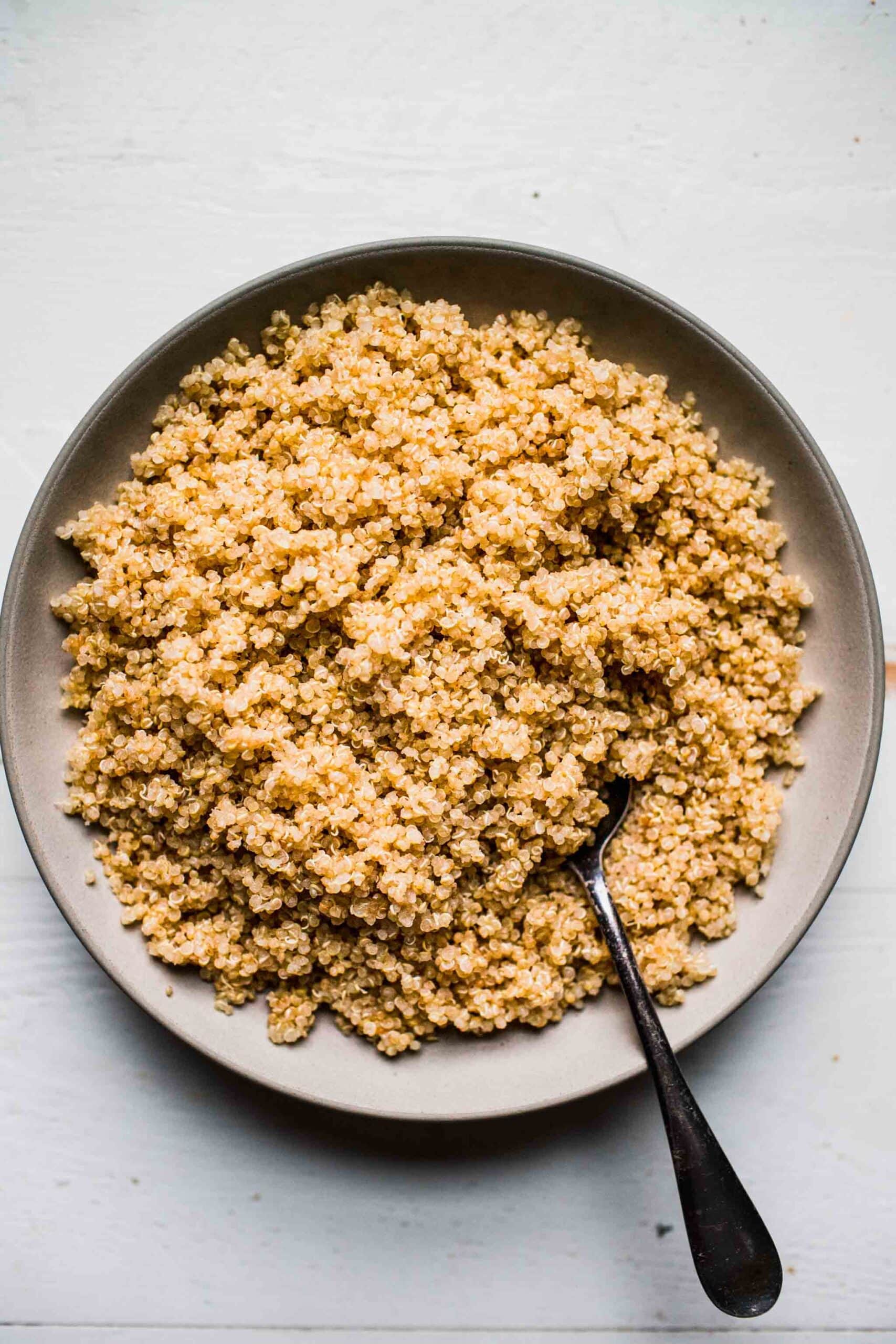 Overhead shot of instant pot quinoa in white bowl with spoon.