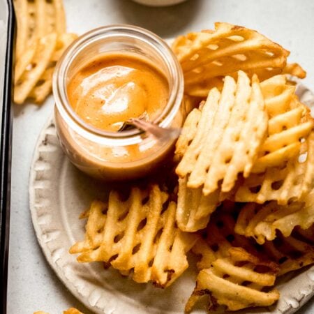 Chick fil a sauce on plate with french fries.
