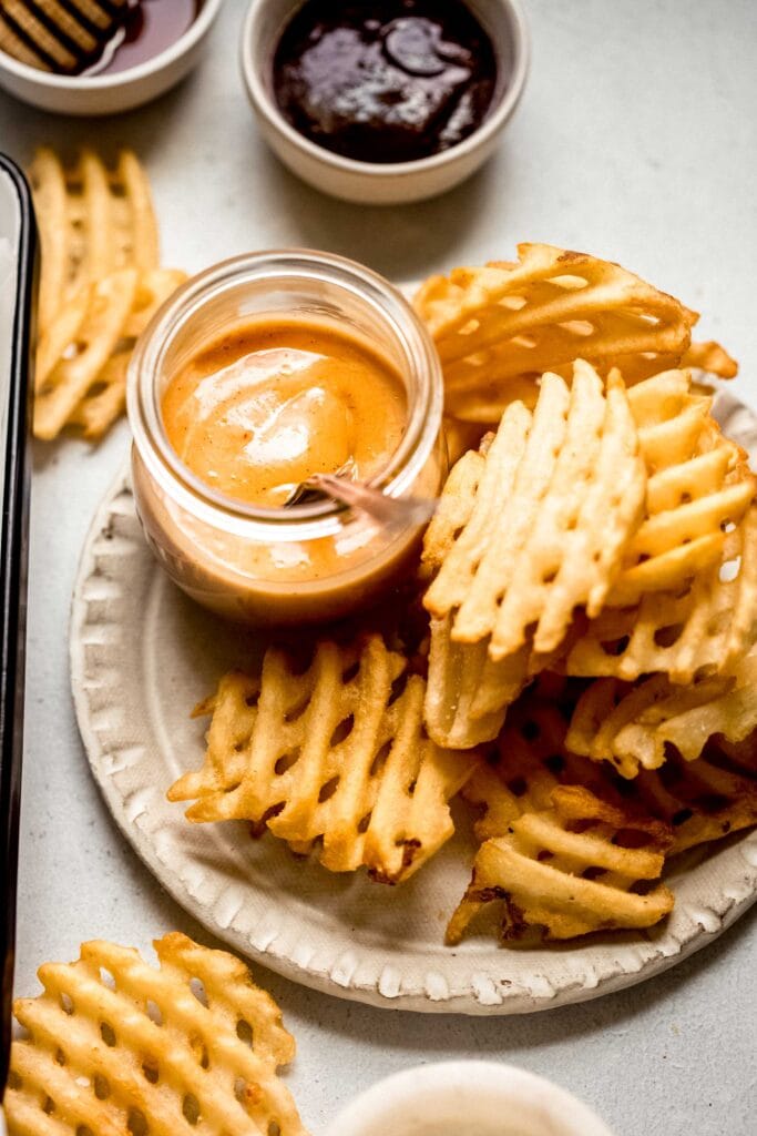 Chick fil a sauce on plate with french fries.