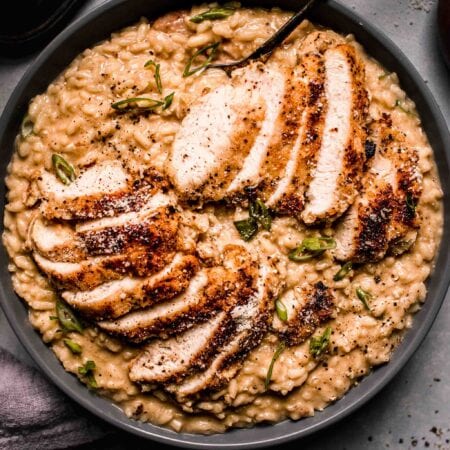 Prepared Chicken risotto in grey serving bowl with spoon.