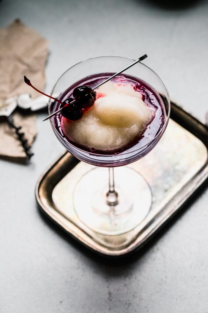 New York Sour Slushie in coupe glass garnished with cherries. 