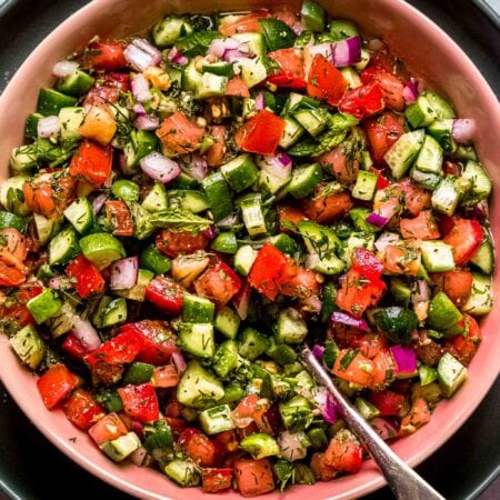 Shirazi salad centered in frame with serving spoon.
