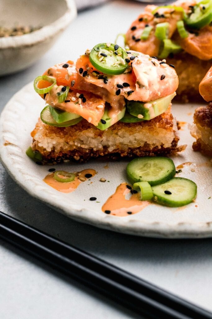 Side view of crispy rice sushi on plate. 