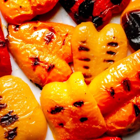 Peppers with grill marks scattered on counter.