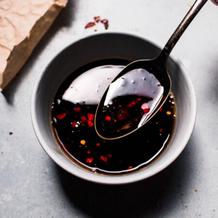 Spoon in small bowl of gyoza dipping sauce.