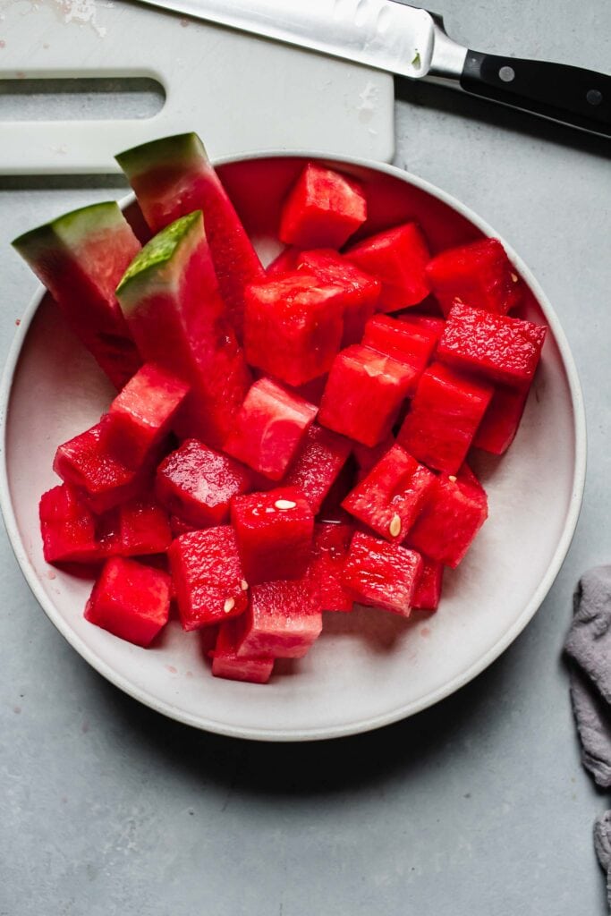 Cubes of watermelon in white bowl.