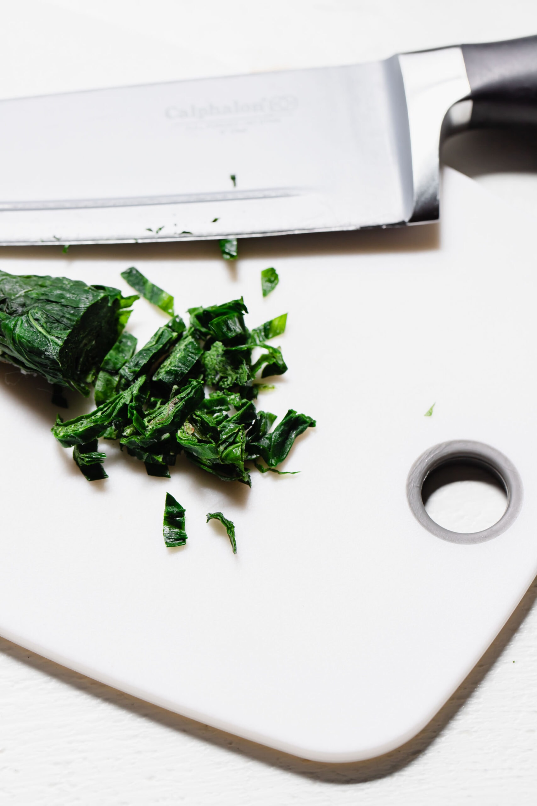 FROZEN ROLL OF BASIL CHOPPED INTO PIECES.