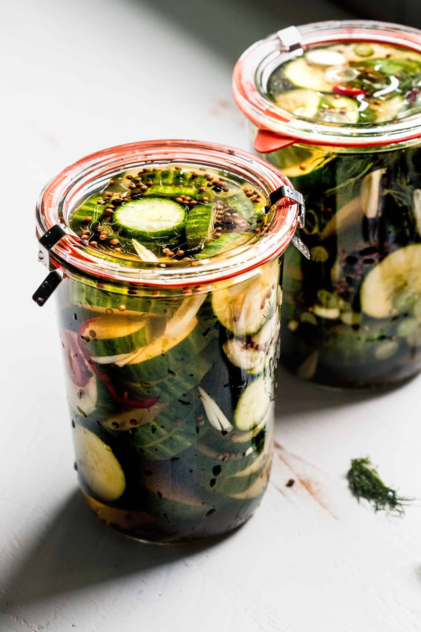 2 jars of pickles with lids on.
