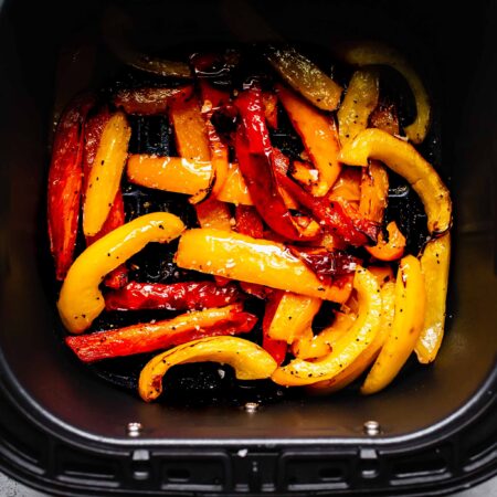 Fried peppers in air fryer basket.