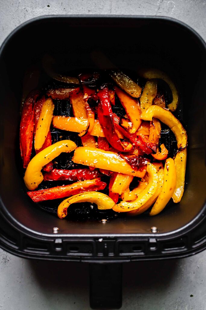 Fried peppers in air fryer basket.