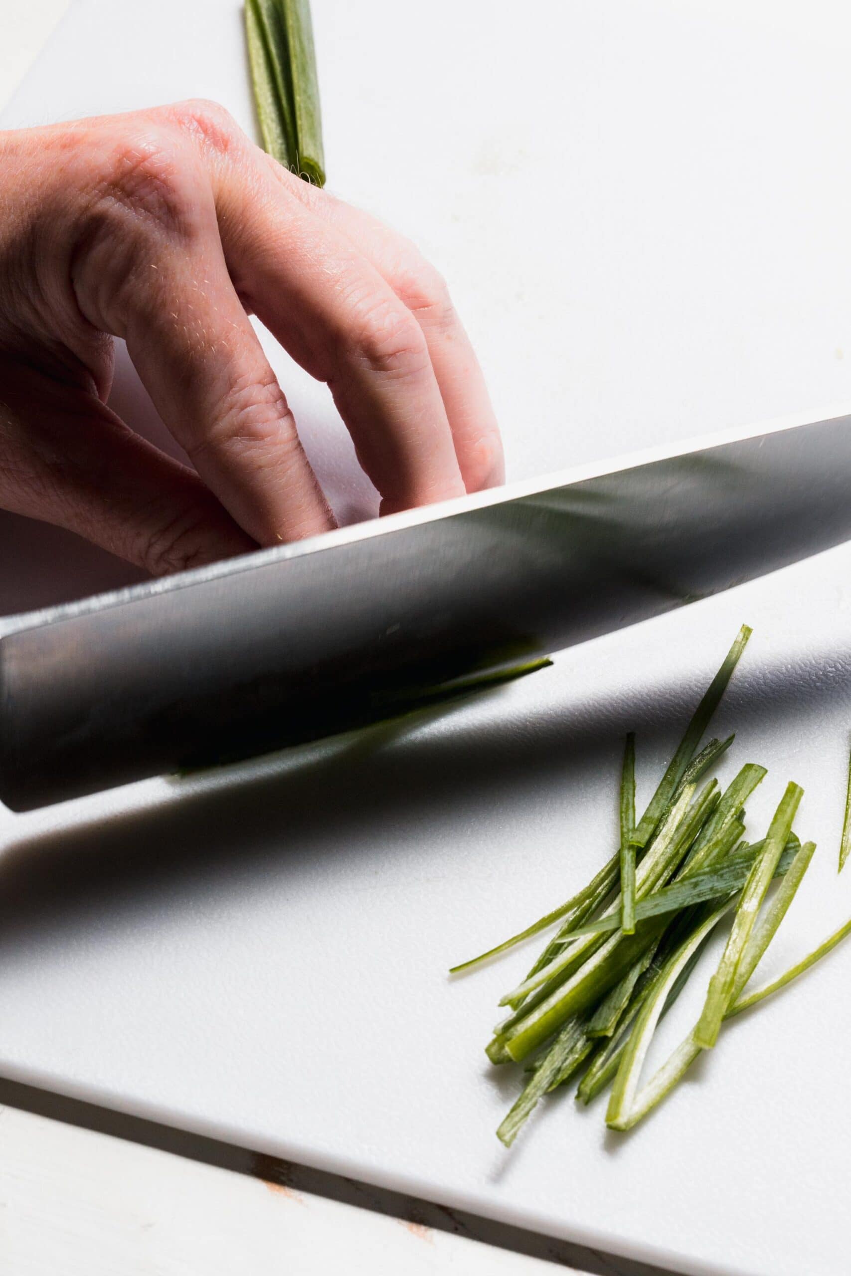 Shreds of green onions being cut. 