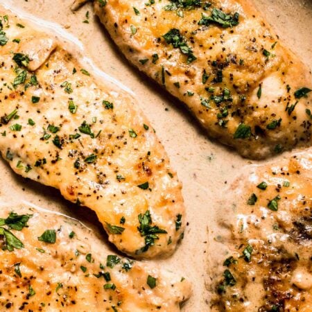 Overhead close up of chicken in white wine sauce in skillet.