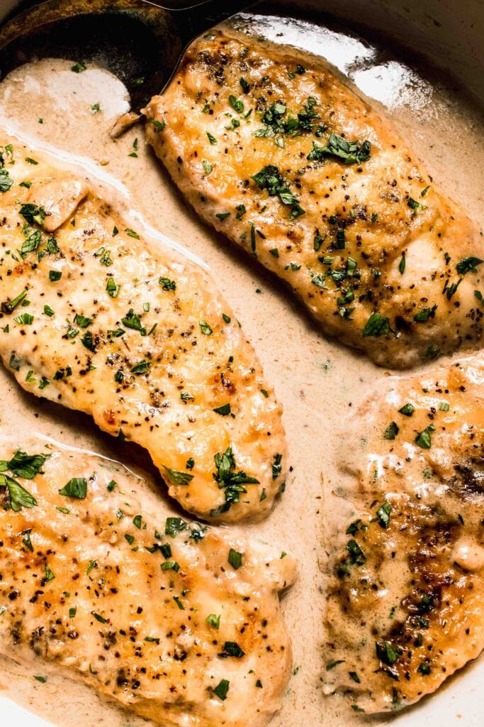 Overhead close up of chicken in white wine sauce in skillet.