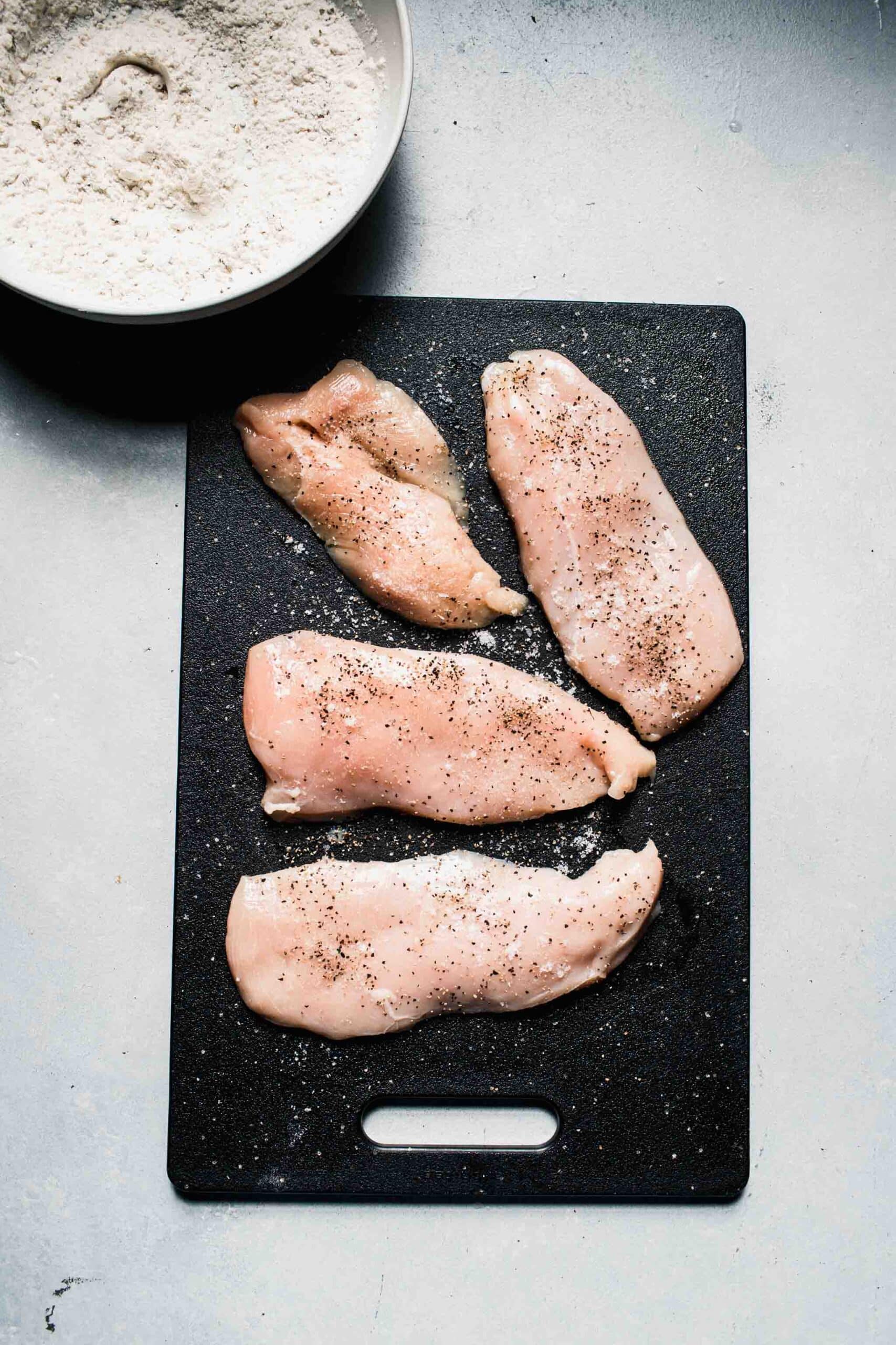 Thin chicken breasts sprinkled with pepper.