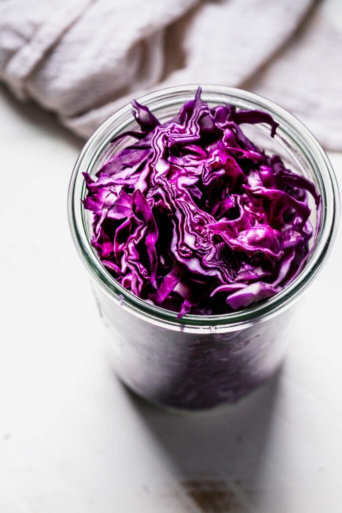 Sliced cabbage packed into jar.
