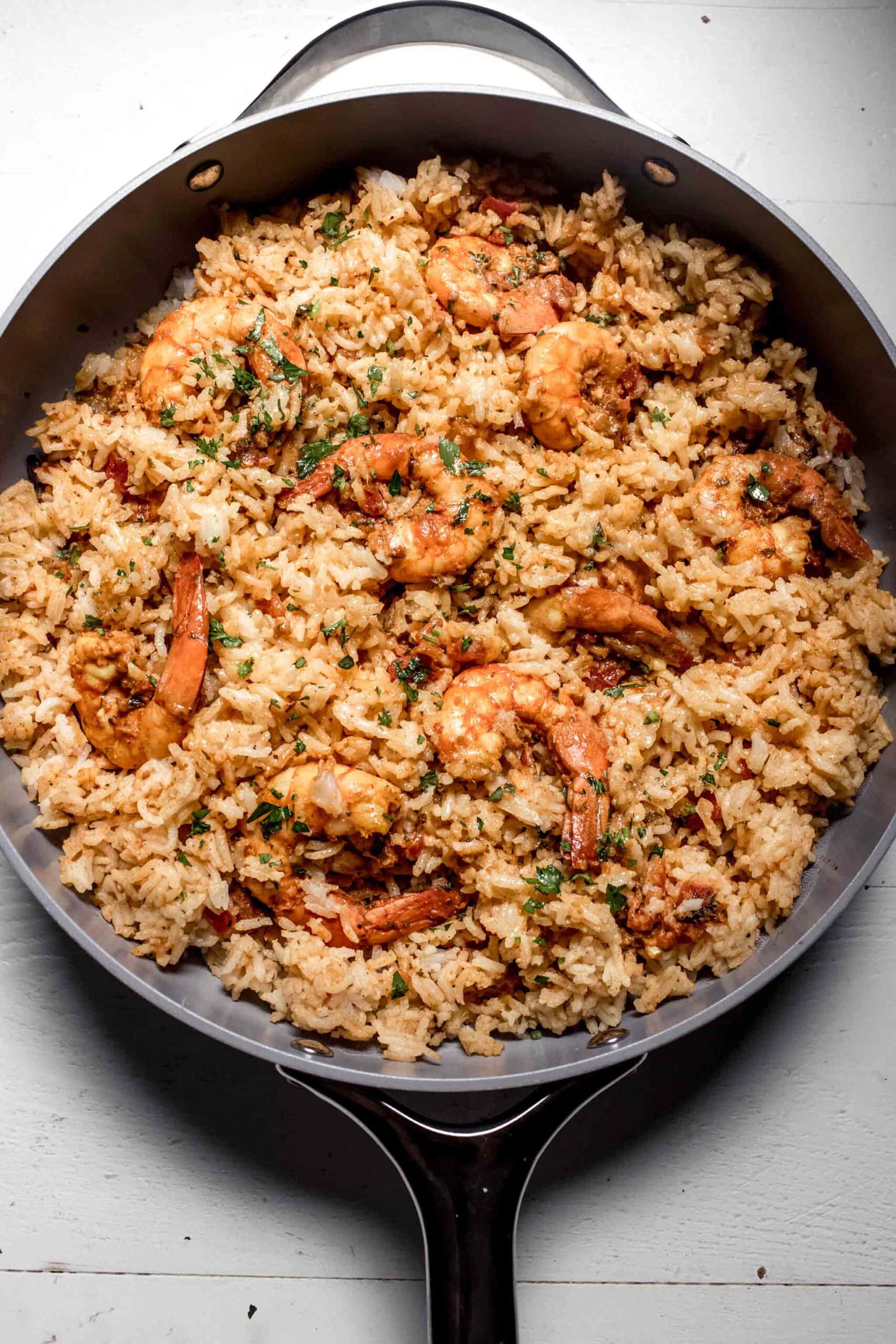 Shrimp layered with rice in skillet. 
