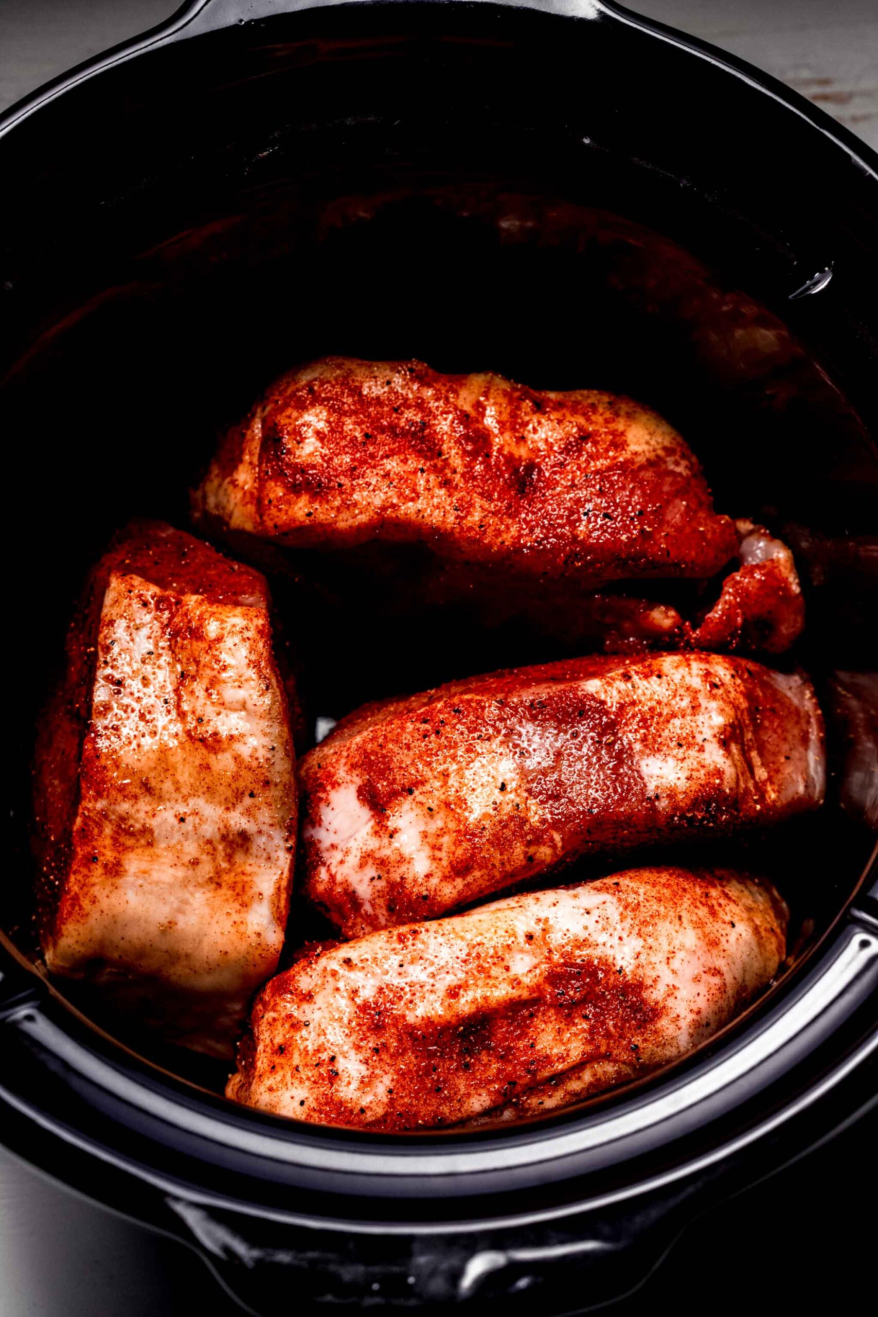 Uncooked pork chops in slow cooker.