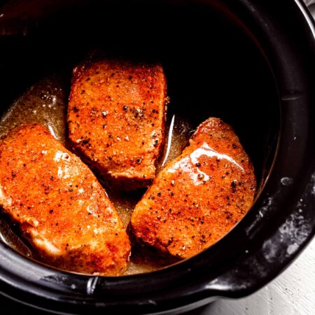 Cooked pork chops in slow cooker.