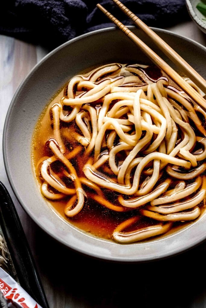 Cooked udon noodles in broth.