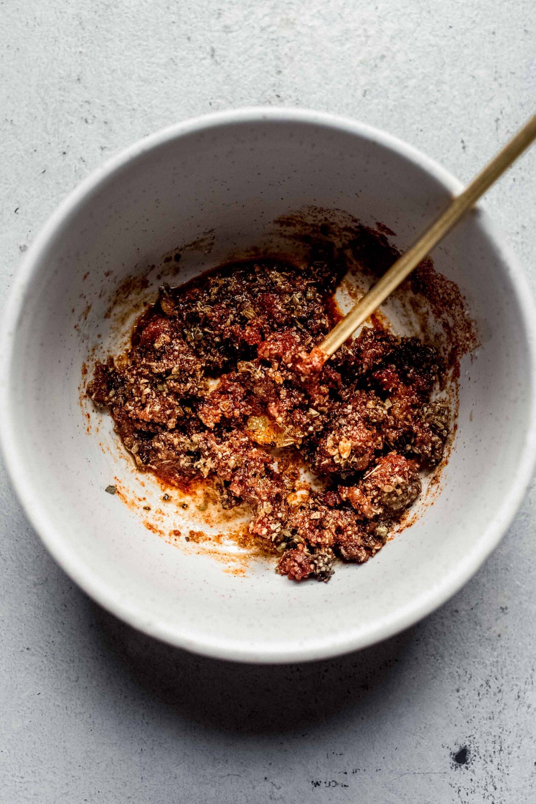 Spices combined with olive oil in small bowl.